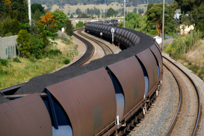 © iStockphoto.com/BeyondImages|A train carrying a load of black coal snakes its way downhill towards the port.