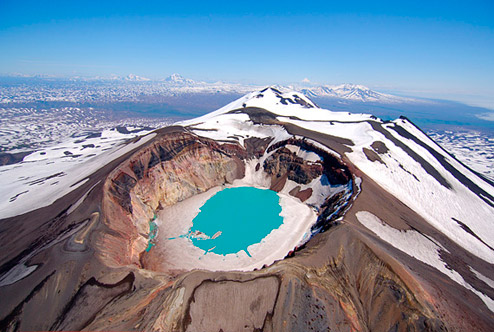 Igor Shpilenok|The azure blue waters filling the crater of Maly Semyachik Volcano are rimmed with ice in June.