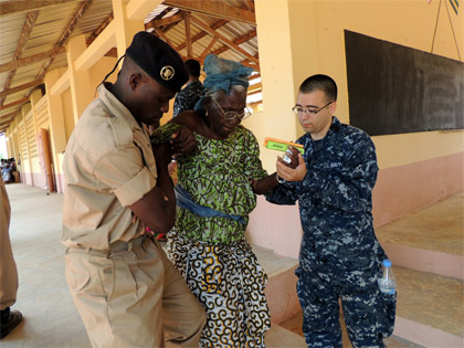 Photo By Kristopher Radder | Hospitalman Justin Garcia and a member of the Togolese military help a woman down the steps during a health fair as part of Africa Partnership Station (APS), September 18, 2012.