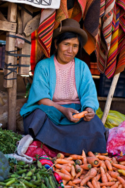 © iStockphoto.com/MarkSkalny|Quechua woman sells vegetables at a market in Pisac, Peru.